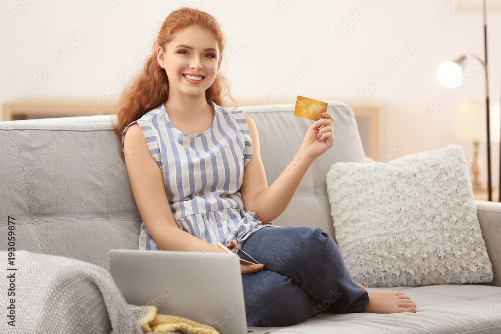 Young woman shopping online with credit card and laptop at home Young woman shopping online with credit card and laptop at home
