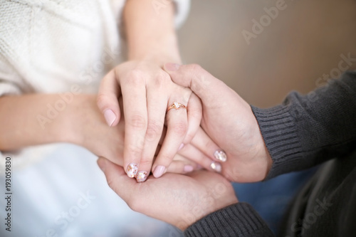 Young man holding hands of his beloved wife, closeup