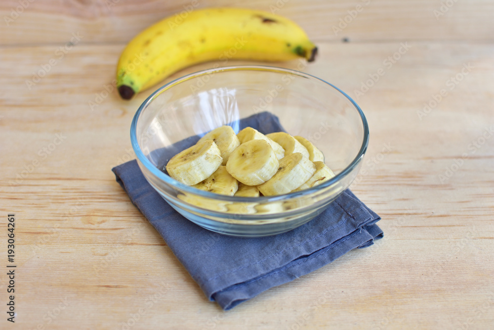 Fresh organic banana slices in bowl on wooden background. Fresh organic banana slices in bowl on wooden background.