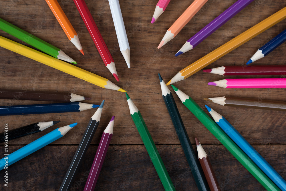 Naklejka premium multicolored pencil on a wooden table. art education and creativity concept