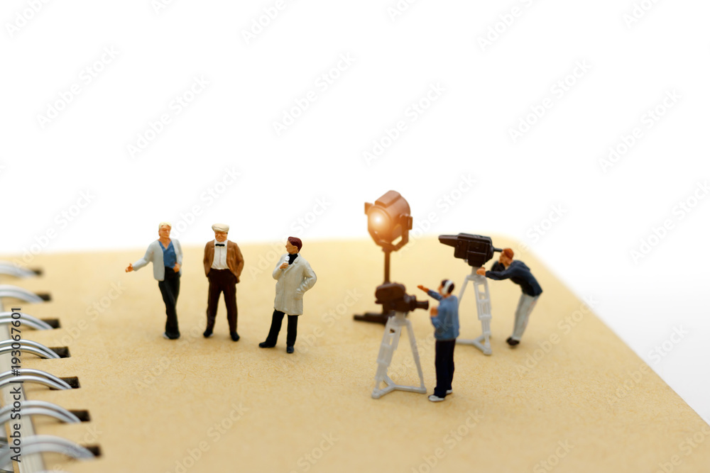 Miniature people: female journalist making an interview a man with a cameraman video camera. Miniature people: female journalist making an interview a man with a cameraman video camera.
