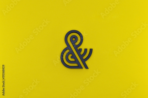 black ampersand with parallel lines on yellow background