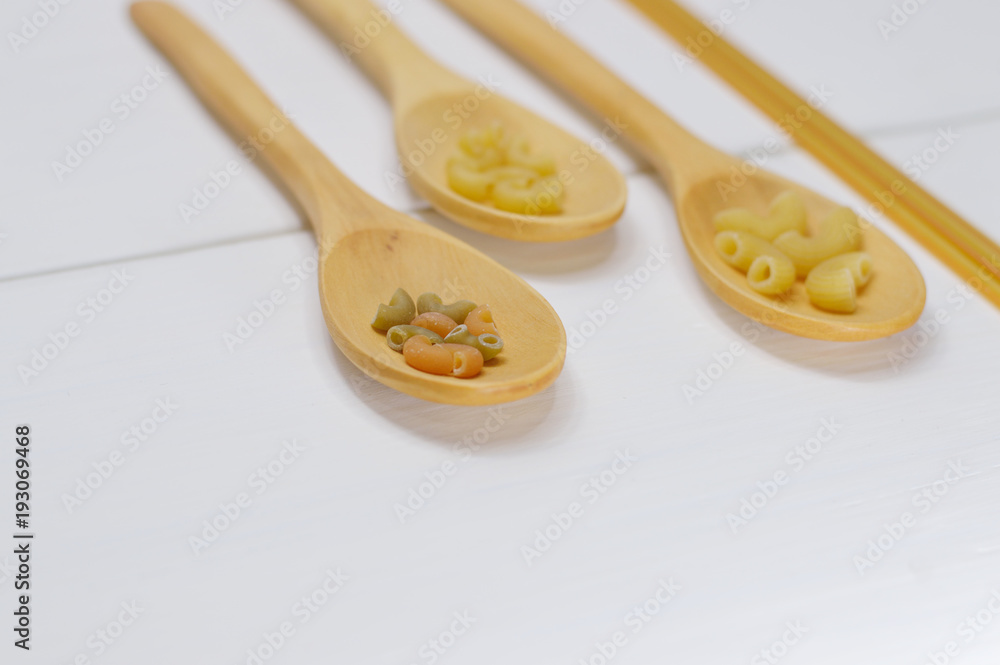three wooden spoons with pasta three wooden spoons with pasta
