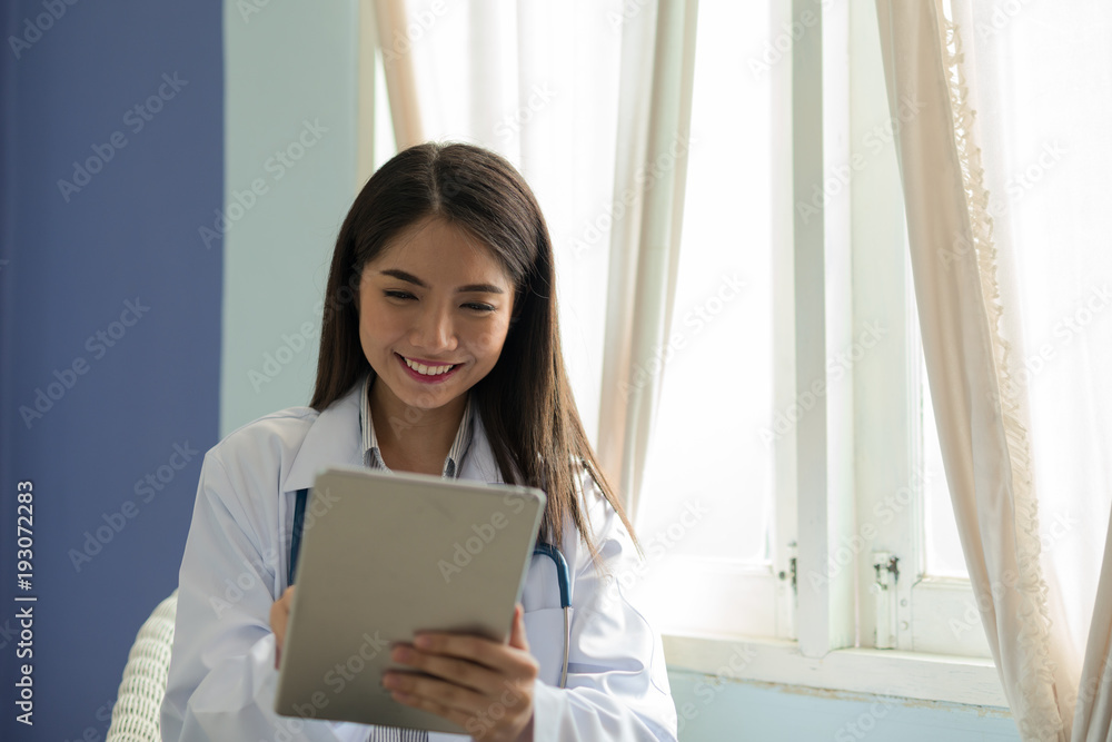 Doctor smiling Asian woman working on a digital tablet. Doctor smiling Asian woman working on a digital tablet.