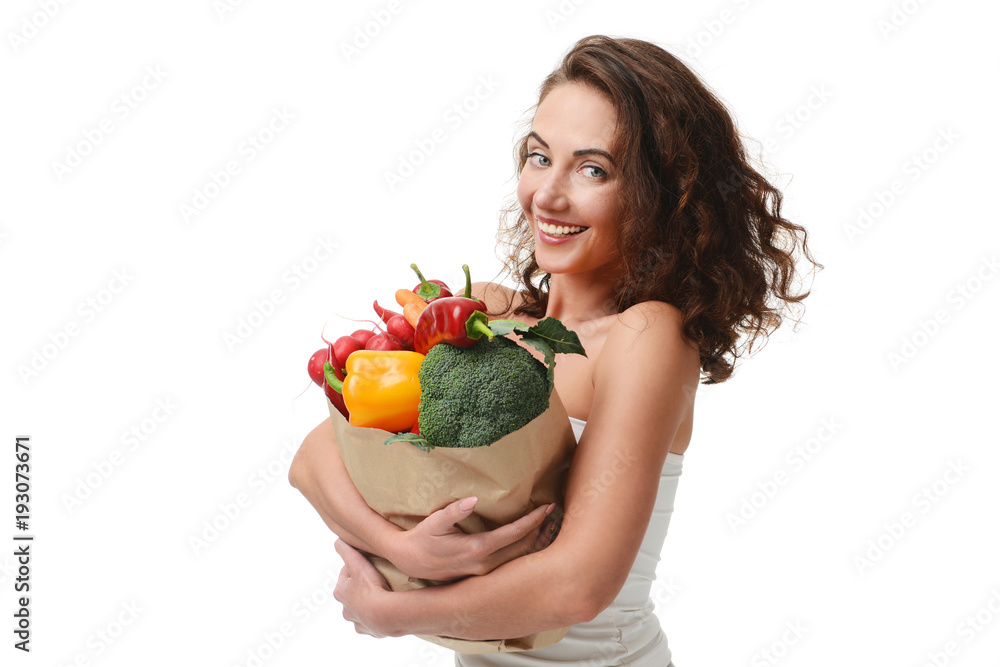 Young woman holding grocery paper shopping bag full of fresh vegetables. Diet healthy eating concept Young woman holding grocery paper shopping bag full of fresh vegetables. Diet healthy eating concept