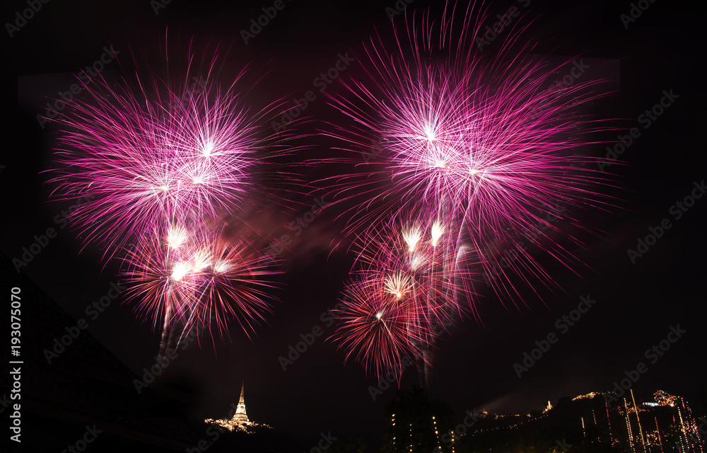 Colorful fireworks explosion with aerial view of buddha temple on the mountain background