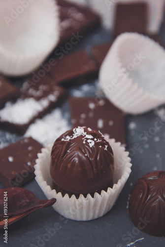 Chocolate Pieces Mix Bar. Sweet Dessert with Coconut Powder. Darck Background. Vertical Image. Toned. photo