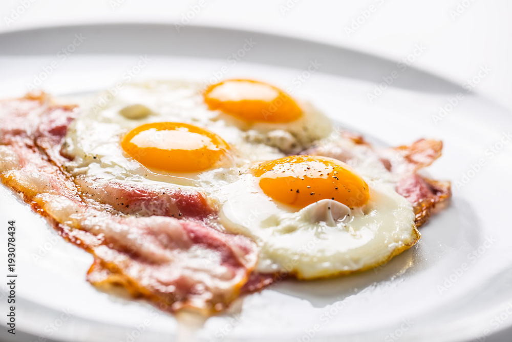 Ham and Eggs. Bacon and Eggs. Salted egg with pepper on white plate. English breakfast Ham and Eggs. Bacon and Eggs. Salted egg with pepper on white plate. English breakfast