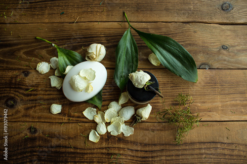 soap and cream with flowers on a wooden background