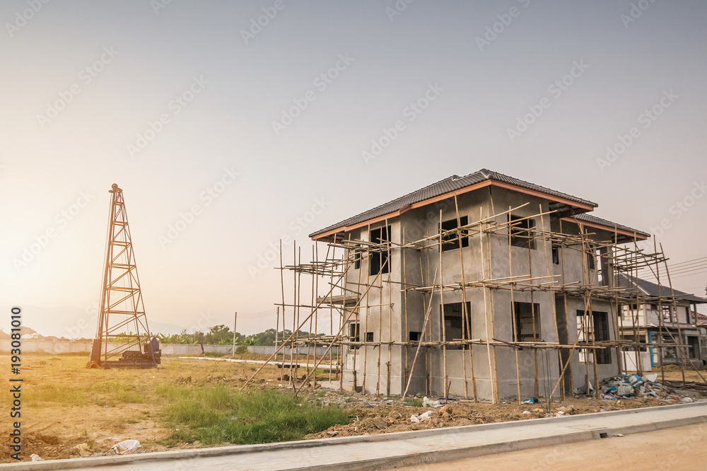 Residential new house building at construction site with clouds and blue sky
