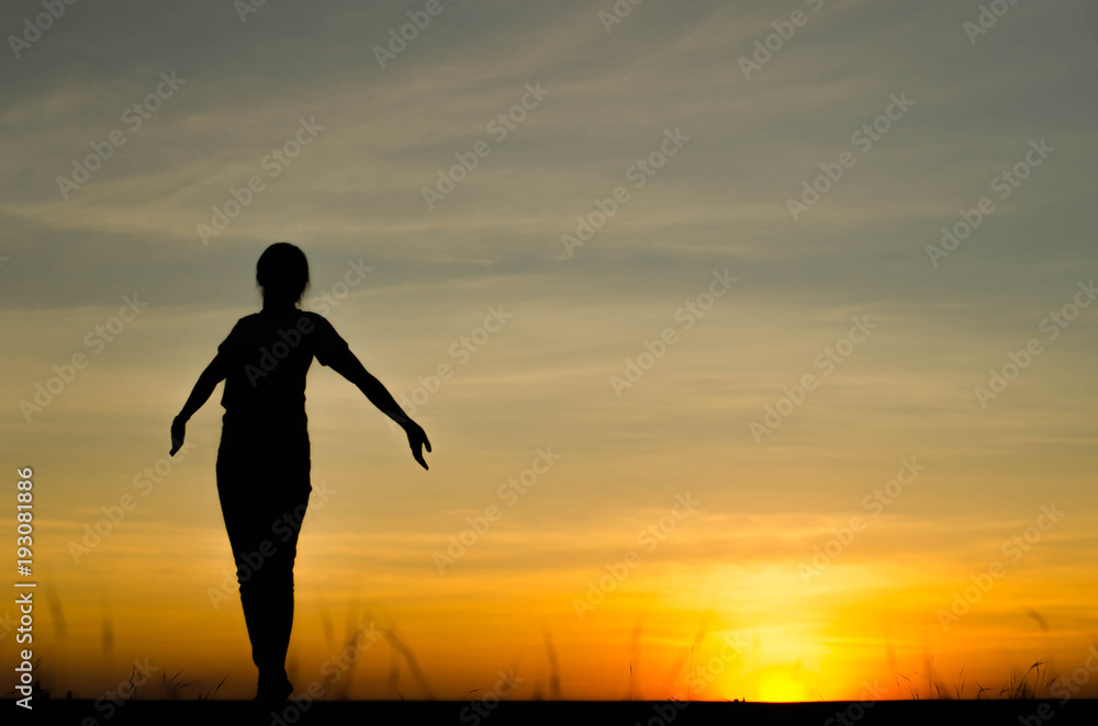 Woman silhouette is standing, raise one's hand for exercise, on evening . Woman silhouette is standing, raise one's hand for exercise, on evening .