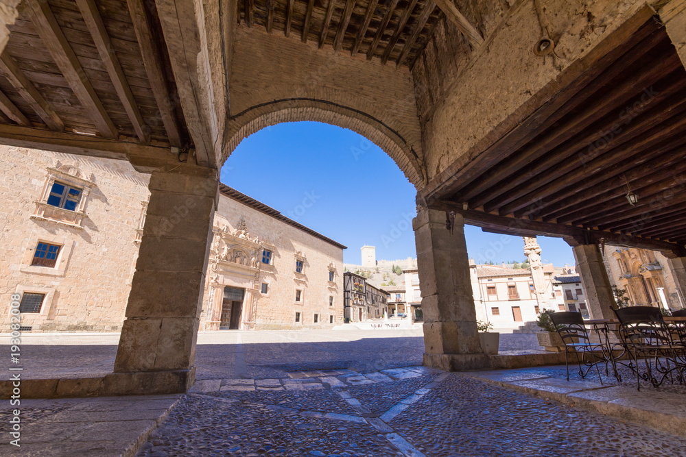 Obraz premium arcade of main square in Penaranda de Duero village, with Palace of the Counts of Miranda, in Burgos, Castile and Leon, Spain, Europe 