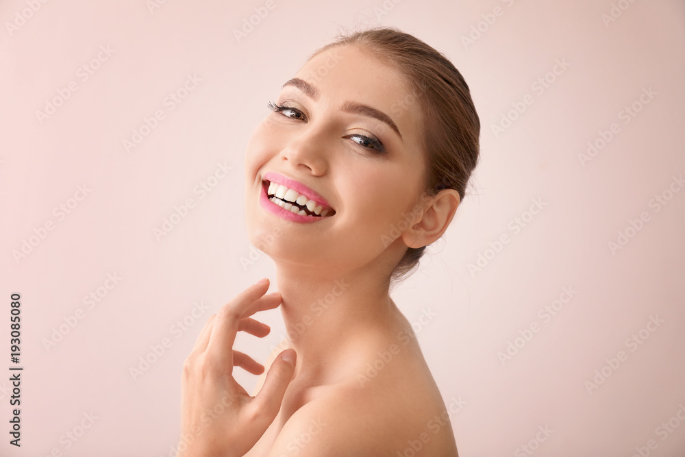 Portrait of beautiful young woman with clear skin on light color background Portrait of beautiful young woman with clear skin on light color background