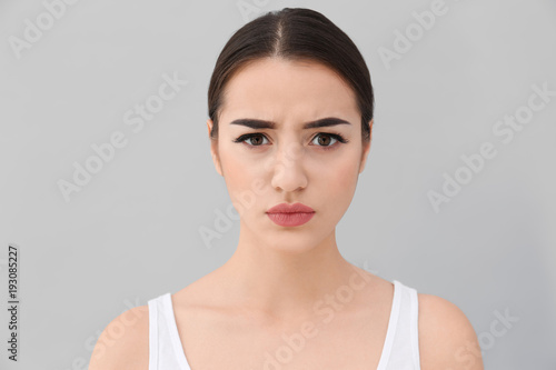 Young woman frowning her ey...