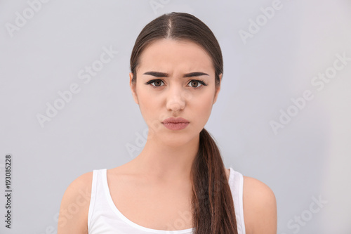 Young woman frowning her ey...