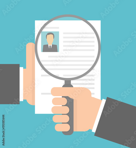 Hand holding magnifying glass over a cv . Recruitment concept