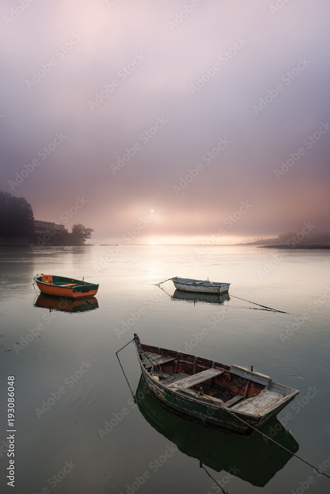 Fototapeta premium Boats in a foggy sunrise