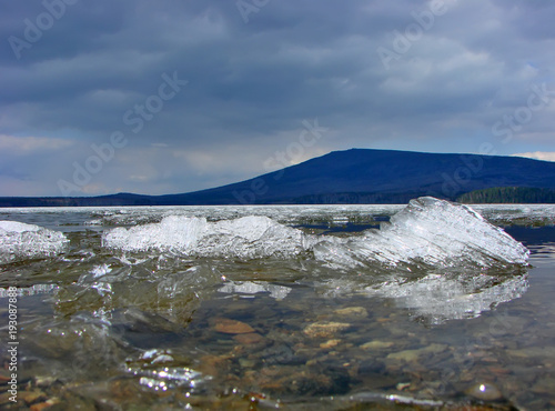 The ice on the Nizhnevoy reservoir against the background of the Kachkanar mountain. Kachkanar. Sverdlovsk region. Russia
