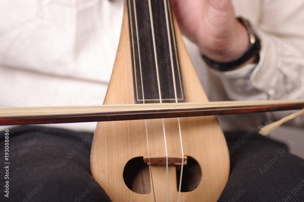 a musician is playing his traditional Turkish string insturment kemence a musician is playing his traditional Turkish string insturment kemence