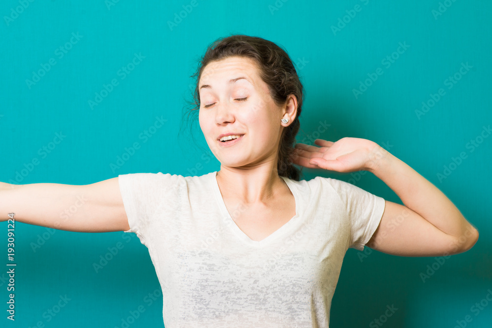 Cheerful girl is stretching her arms after sleeping. She closed her eyes happily and smiling. Cheerful girl is stretching her arms after sleeping. She closed her eyes happily and smiling.
