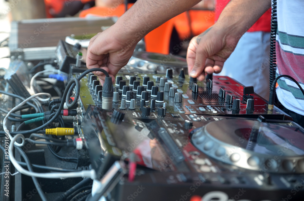 Hands of the DJ behind the installation on the beach party Hands of the DJ behind the installation on the beach party