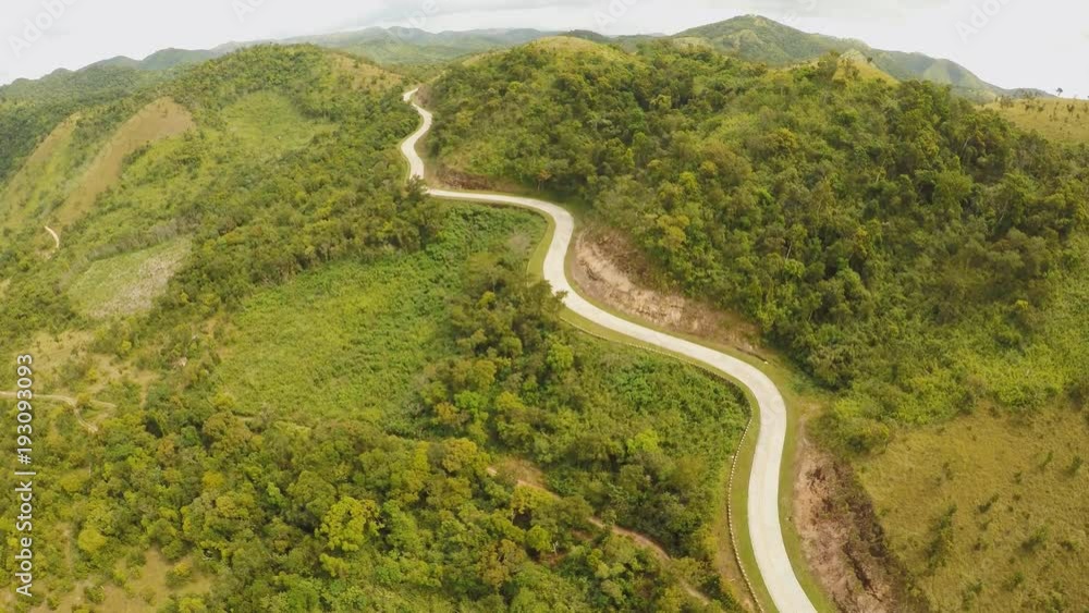 A long and winding road passing through green hills. Busuanga island. Coron. Aerial view. Philippines. A long and winding road passing through green hills. Busuanga island. Coron. Aerial view. Philippines.