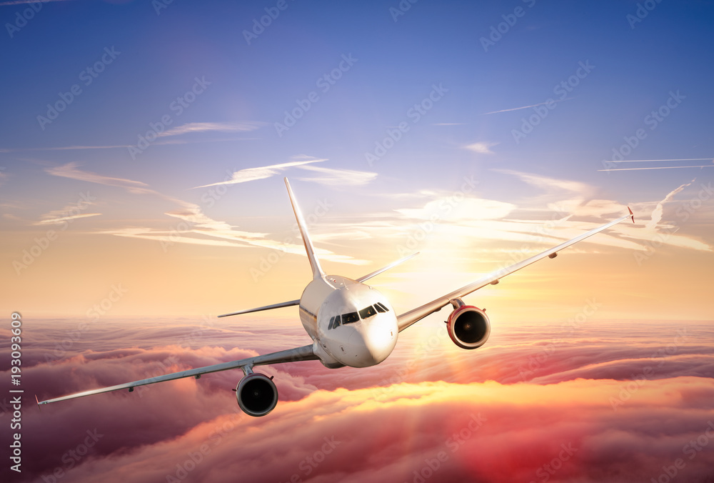 Fototapeta premium Samolotowy odrzutowiec lata nad chmury w pięknym zmierzchu