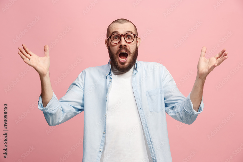 The young attractive man looking suprised isolated on pink The young attractive man looking suprised isolated on pink