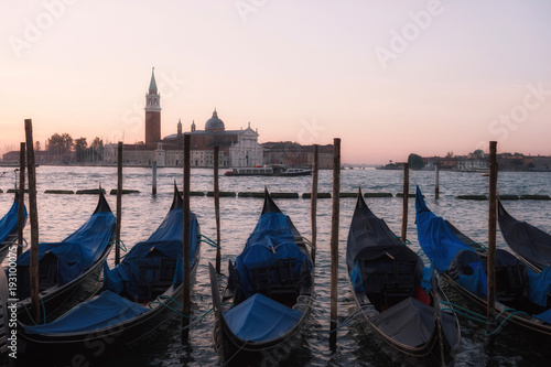 Venice classic sunrise view with gondolas on the waves
