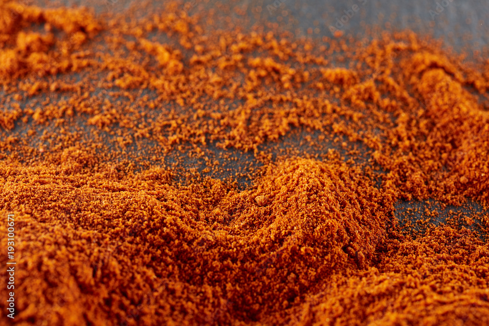 Top view on paprika or red hot chilli pepper powder texture background, shallow depth of field.