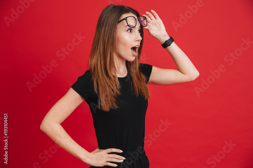 Фотография Closeup image of young woman 20s wearing black t-shirt taking off glasses and lo