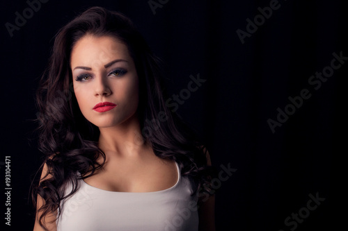 Gorgeous young woman posing against dark studio background
