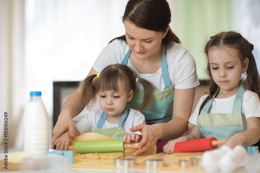 Mom and daughters children bake cookies in the kitchen Mom and daughters children bake cookies in the kitchen