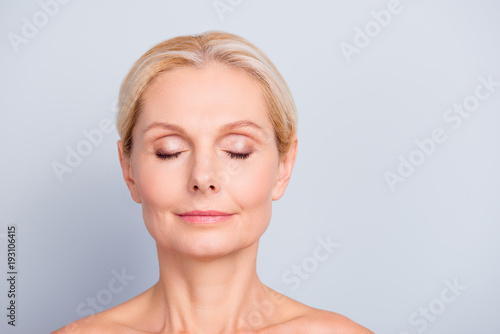 Close up portrait of charming, pretty, attractive woman with perfect skin after cream, balm, mask, lotion, isolated on grey background, having eyes closed, natural maqullage, make up