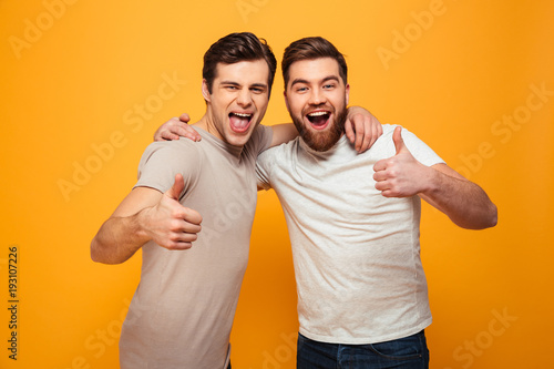 Portrait of a two happy young men showing thumbs up