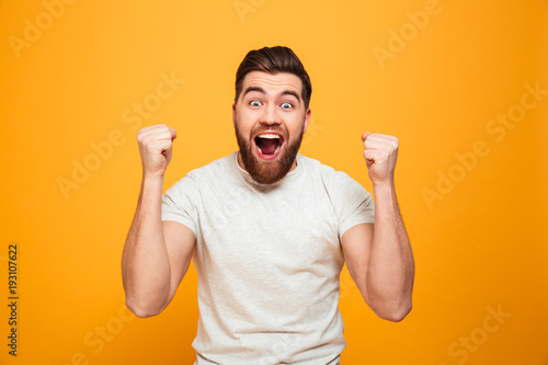 Portrait of an excited bearded man celebrating success