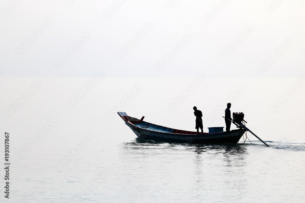 Silhouette of the long tail boat with local people while running in the sea Silhouette of the long tail boat with local people while running in the sea