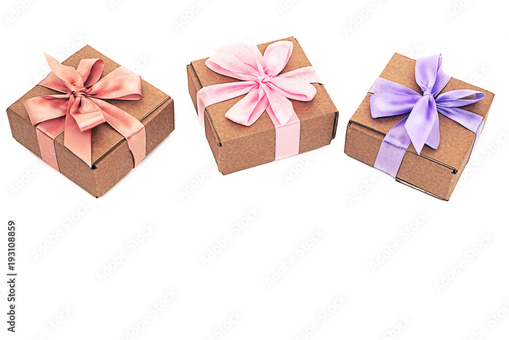 Three festive boxes with gifts tied with satin ribbon on a white background. Three festive boxes with gifts tied with satin ribbon on a white background.