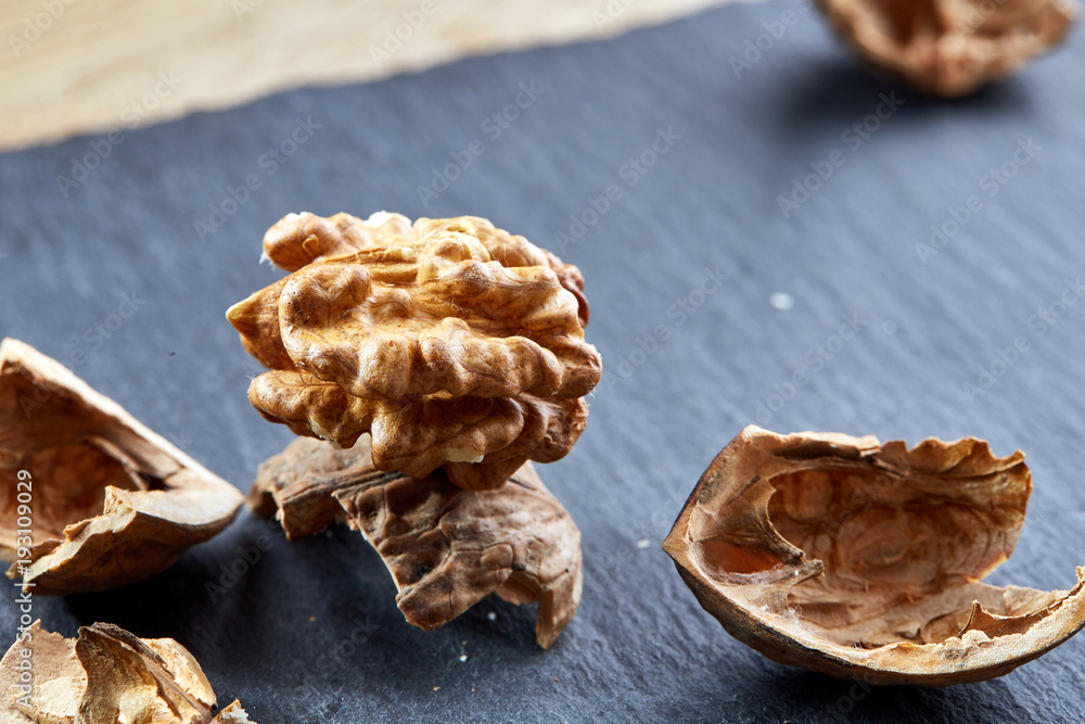 Top view close-up shot of cracked walnuts on dark background, shallow depth of field, macro Top view close-up shot of cracked walnuts on dark background, shallow depth of field, macro