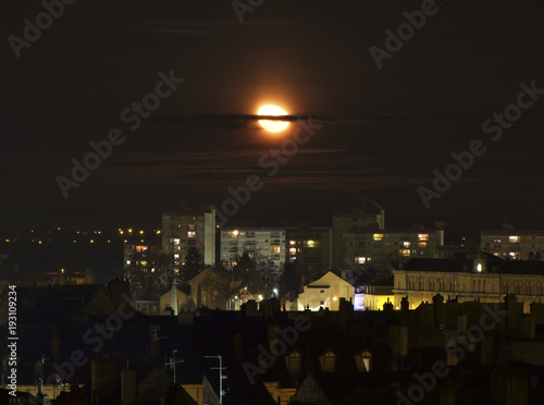 Lune qui éclaire une ville la nuit.