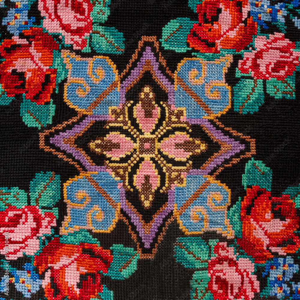Fototapeta premium Embroidery hand made cross-stitch pattern in ethnic style on a black background fashion trend 2018
