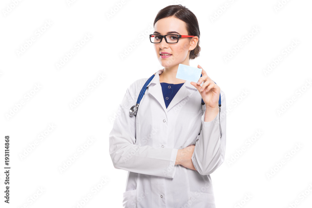 Successful young woman doctor with stethoscope with arms crossed showing business card in white uniform on white background Successful young woman doctor with stethoscope with arms crossed showing business card in white uniform on white background