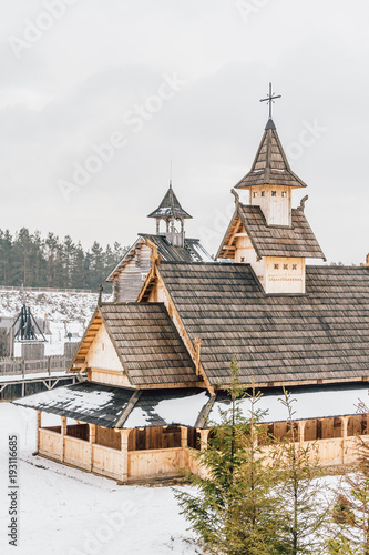 Ancient wooden Slavic church on a snowy landscape. Historical and Architectural Museum in the open air. Kiev, Ukraine. photo