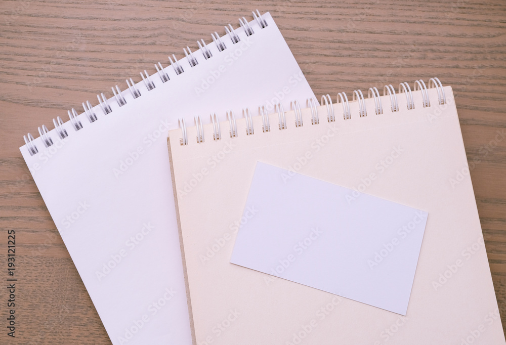 Empty business card on opened notebook Empty business card on opened notebook