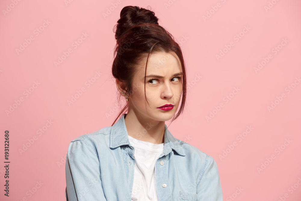 Suspiciont. Doubtful pensive woman with thoughtful expression making choice against pink background