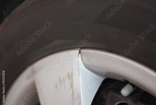 Fotografía Silver car tire rim is broken and scratched because of hitting something, cracke