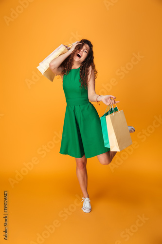 Happy young woman holding shopping bags.