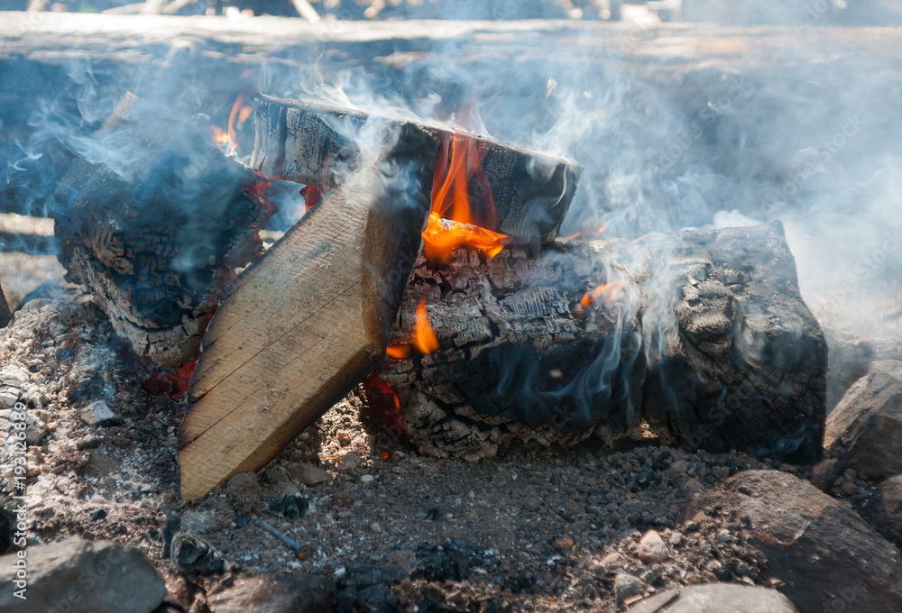 Low-burning fire surrounded by stones Low-burning fire surrounded by stones