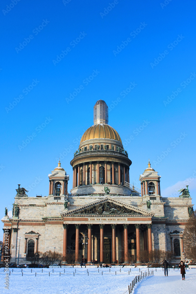 Saint Isaac's Cathedral Winter View in St. Petersburg, Russia. Famous City Symbol Landmark on Cold Sunny Day. Outdoor Scenic Park Nature with Snow and Clear Blue Sky Background with No People Around.