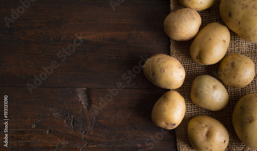 Fresh potatoes on an old wooden table